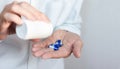 Female hand close up holding a medicine, elderly woman hands with pill on spilling pills out of bottle Royalty Free Stock Photo