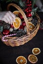 Female hand collects a wicker basket with Christmas decorations and goods as a gift Royalty Free Stock Photo