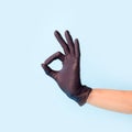 Female hand in cosmetology medicine black glove pointing up okay, yes, accepting hand sign to the side, studio shot, copy space, Royalty Free Stock Photo