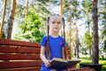 Cute little girl is reading a book outdoors Royalty Free Stock Photo