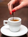 Female hand with cup of espresso coffee and spoon. Royalty Free Stock Photo