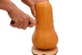 Female hand cuts a pumpkin with knife on a wooden board. Isolated, horizontal photo, healthy eating concept