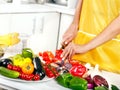 Female hand cutting vegetable at kitchen.