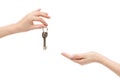 Female hand delivers keys to other hand on white background.