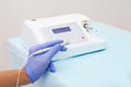 Female hand of dentist in blue gloves holding ultrasonic teeth cleaning machine removing calculus and plaque. Oral