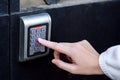 Female hand dials the access code on the electronic lock.