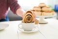 Female hand dipping a sweet roll on her hot chocolate