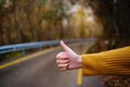 female hand doing hitchhiking sign near the country roadside. Royalty Free Stock Photo