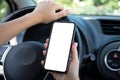 female hands driving car holding phone with isolated screen