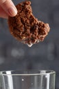Female hand dunking cookie in milk close up
