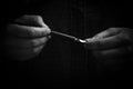 Female hand elegantly holding an ink pen with a metal tip close-up on a black background. classic fountain pen macro