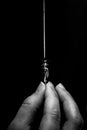 Female hand elegantly holding an ink pen with a metal tip close-up on a black background. classic fountain pen isolated macro Royalty Free Stock Photo