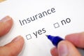 female hand fills out a questionnaire with check-box - insured yes or no? insurance checklist selection over a white background Royalty Free Stock Photo