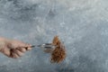 Female hand filtering raw buckwheat with strainer