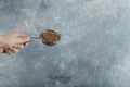 Female hand filtering raw buckwheat with strainer