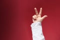 Female hand, finger gesture number three, red cloth background, space for designer, finger counting concept, arithmetic
