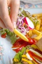 Female hand fingers holding and dipping fried French fries in tomato ketchup on a plate, beautiful vegetarian Breakfast, vertical