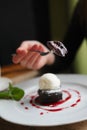 Shallow depth of foeld photo of brownie cake with ice-cream. Hand of girl with fork Royalty Free Stock Photo