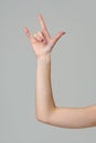 Female hand gesturing rock sign on gray background close up Royalty Free Stock Photo