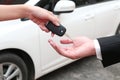 Female hand giving a key for buyer or rental car.