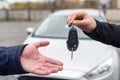 Female hand giving and male hand receiving car keys