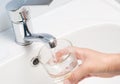 Female hand with a glass under the tap