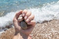 Female hand with glitter nail design holding sea pebbles Royalty Free Stock Photo