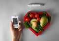 Female hand with glucometer, lancet pen and healthy food on grey background. Diabetes diet Royalty Free Stock Photo