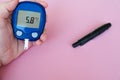 Female hand with glucometer. Gestational diabetes mellitus concept. Woman doing blood glucose measurement.