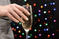 Female hand with golden nail design. Gold glitter nail polish manicure. Woman hold champagne glass on bokeh background Royalty Free Stock Photo