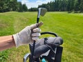 Female hand of golfer in glove holds bag with golf clubs Royalty Free Stock Photo