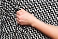 Female hand grasping or clutching silk bed sheet with geometric print in ecstasy. Sex, orgasm, sexual pleasure concept Royalty Free Stock Photo