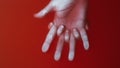 Female hand grasps a man`s palm between the fingers in red water, the concept love strenght, cover for art in the horror genre