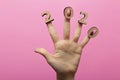 Female hand greets 2020 new year on a colored pink background, wooden figures of numbers on female fingers with a date Royalty Free Stock Photo