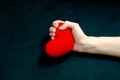 The female hand grips the red heart tightly. Protest of unrequited love