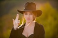 Female hand in gun gesture. Close up face of young stylish woman. Beautiful fashionable girl outdoor portrait. Royalty Free Stock Photo