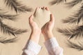 Female hand with a handful of sand among shadow of a palm tree branch of a sandy tropical beach. Holiday concept. Creative Royalty Free Stock Photo