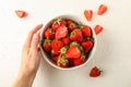 Female hand hold bowl with fresh strawberries on white background, space for text. Summer sweet fruits Royalty Free Stock Photo