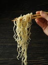 Female hand hold chopsticks with noodles on wooden background Royalty Free Stock Photo