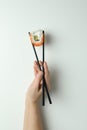 Female hand hold chopsticks with roll on white background Royalty Free Stock Photo