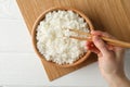 Female hand hold chopsticks on wood background with delicious rice Royalty Free Stock Photo