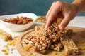 Female hand hold granola bar on wooden background with granola bars Royalty Free Stock Photo