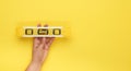 Female hand hold plastic yellow level tool with capsules on a yellow background Royalty Free Stock Photo