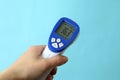 Female hand hold thermometer gun on blue background Royalty Free Stock Photo