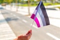 Female hand holding an asexual pride flag