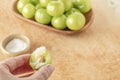 Female hand holding biten gren plum with salt Royalty Free Stock Photo