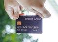 female hand holding a black credit card mockup with security chip embedded, Bokeh background Royalty Free Stock Photo