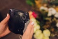 Female hand holding black instant camera close-up. Royalty Free Stock Photo