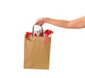 Female hand holding blank brown papaer shopping bags full of gift boxes ornamented Royalty Free Stock Photo