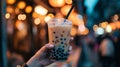Female hand holding Bubble tea Asian sweet cold tapioca pearls drink night city.